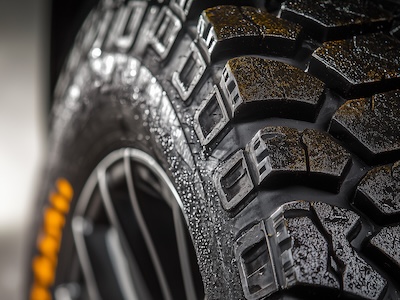 Off road car wheel thread in close up background.